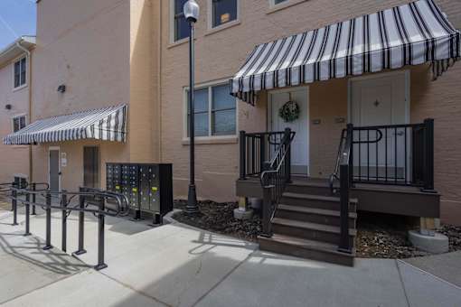 A building with a striped awning and a black and white door.