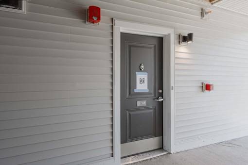 A grey door with a sign on it.