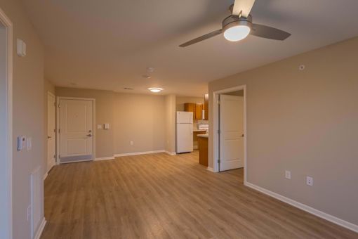 A room with a ceiling fan and wooden flooring.