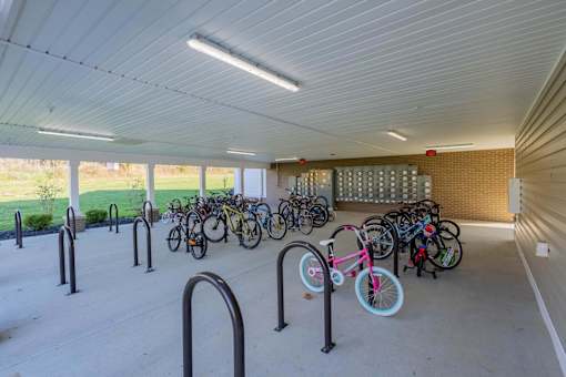 A bicycle parking area with a white ceiling and grey floor.