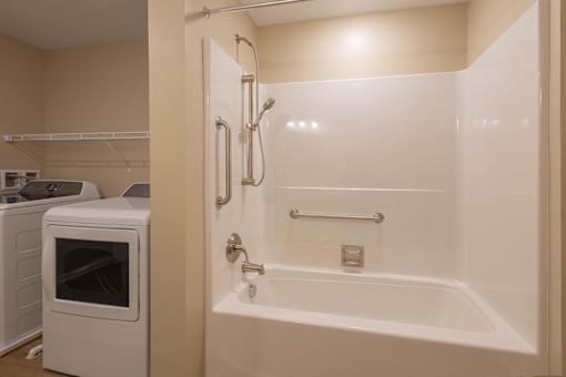 A white bathtub with a shower head and hand held shower.