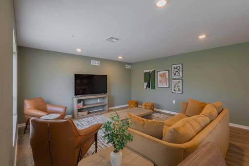 A living room with a brown couch, a brown chair, and a television.