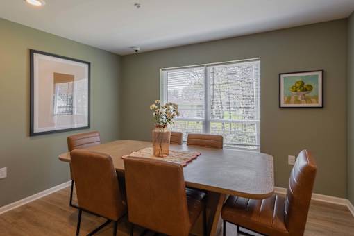 A dining room with a table and chairs.
