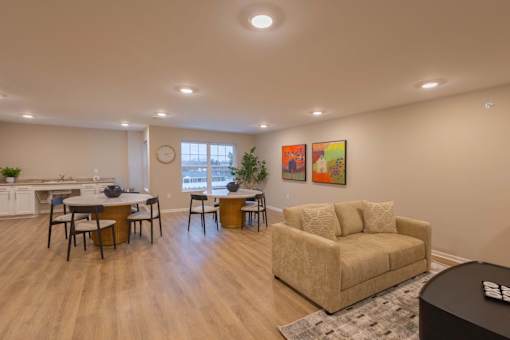 A living room with a couch, chairs, and a dining table.