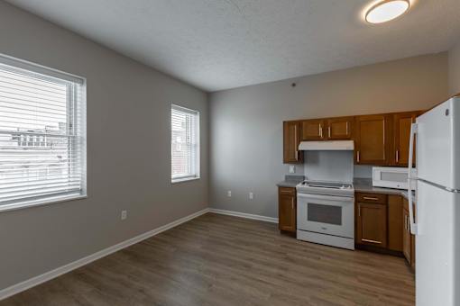 A kitchen with white appliances and wooden cabinets.