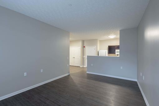 A large empty room with wooden floors and white walls.