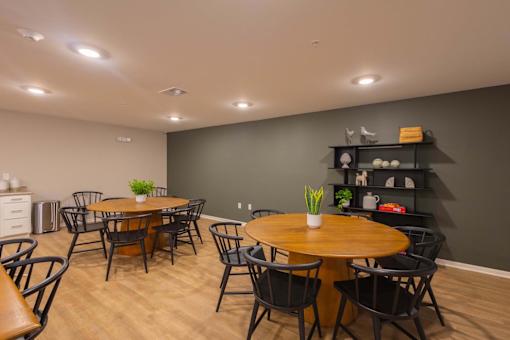 A dining room with a wooden table surrounded by chairs.