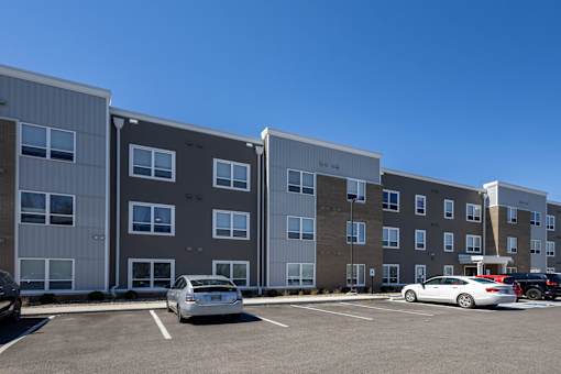 A parking lot with cars and apartment buildings.
