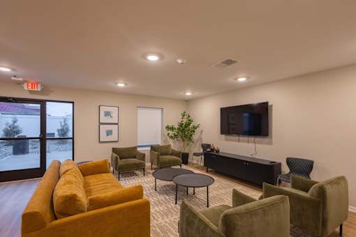 A living room with a yellow couch and a flat screen TV.