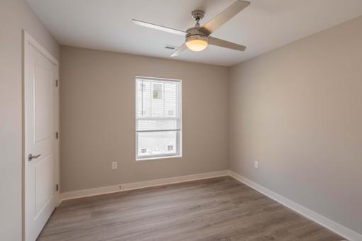 A room with a ceiling fan and a window.