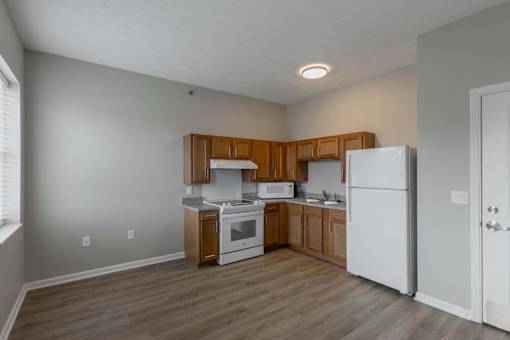 A kitchen with wooden cabinets and white appliances.