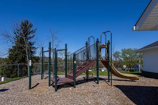 A playground with a slide and monkey bars.