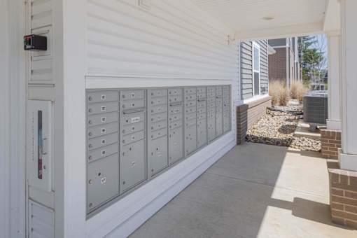 A row of mailboxes are lined up on the side of a building.