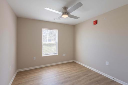 A room with a ceiling fan and a window.