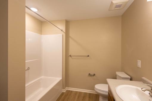 A bathroom with a toilet, sink, and bathtub.