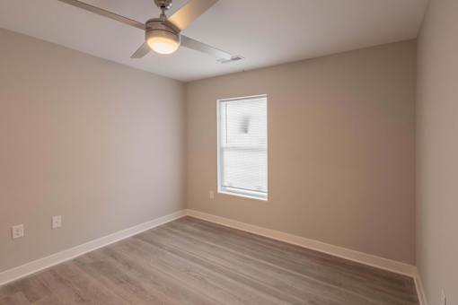 A room with a ceiling fan and a window.