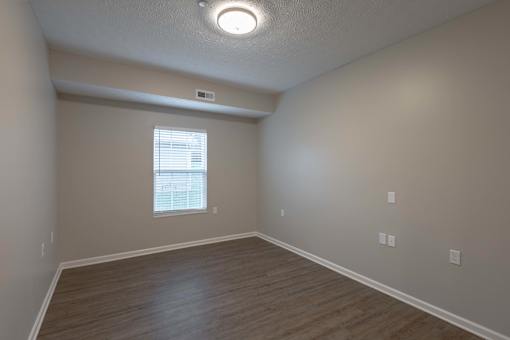 A room with a window and wooden flooring.
