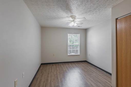 A room with a ceiling fan and a window.