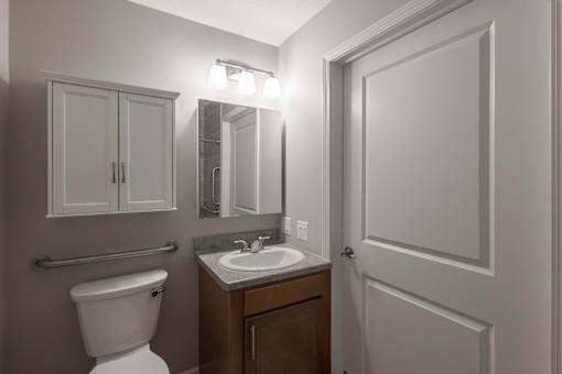 A bathroom with a toilet, sink, and medicine cabinet.