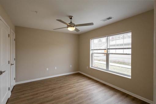 A room with a ceiling fan and a window.