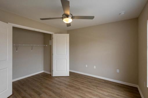 A room with a ceiling fan and a door.