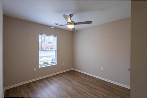 A room with a ceiling fan and a window.