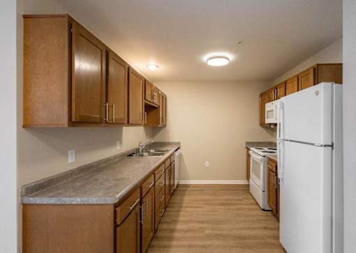 A kitchen with wooden cabinets and a white refrigerator.