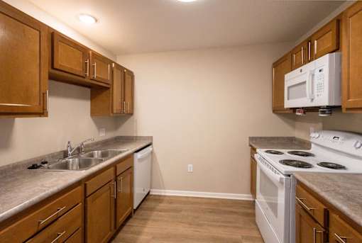 A kitchen with wooden cabinets and a white oven.