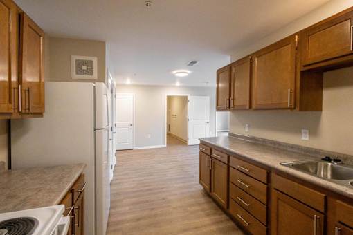 A kitchen with wooden cabinets and a white refrigerator.