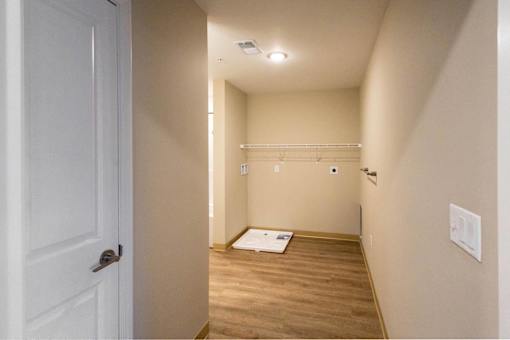 A hallway with a white door and a white wall.
