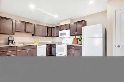 A kitchen with brown cabinets and white appliances.