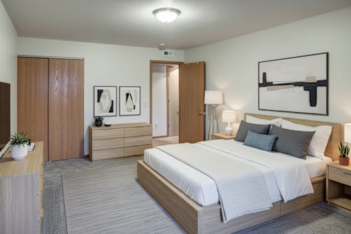 A bedroom with a large bed, a nightstand, and a dresser.