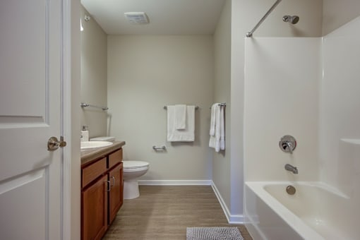 A white bathroom with a toilet, sink, and bathtub.