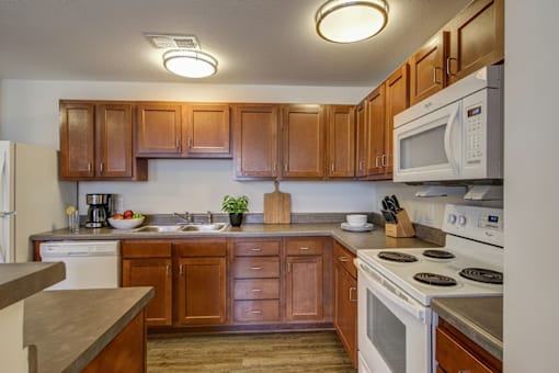 A kitchen with wooden cabinets and a white stove top oven.