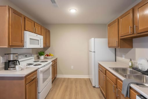 A kitchen with wooden cabinets and white appliances.