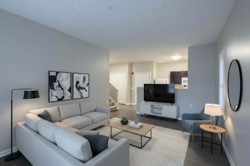 A living room with a white couch and a television.
