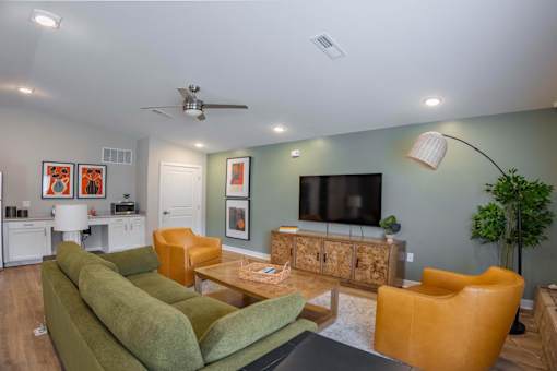 A living room with a green couch and a television.
