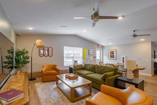 A living room with a green couch, a brown coffee table, and a ceiling fan.