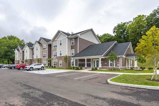 A parking lot in front of a large apartment complex.