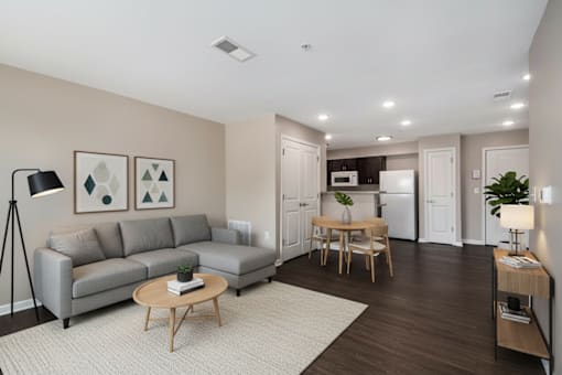 A living room with a grey couch, a coffee table, and a lamp.