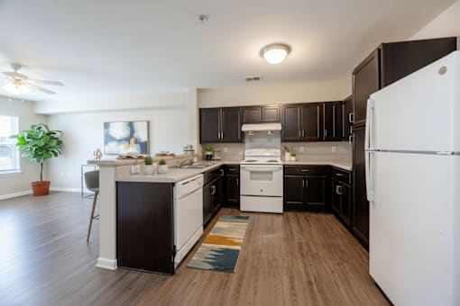 A modern kitchen with black cabinets and a white refrigerator.