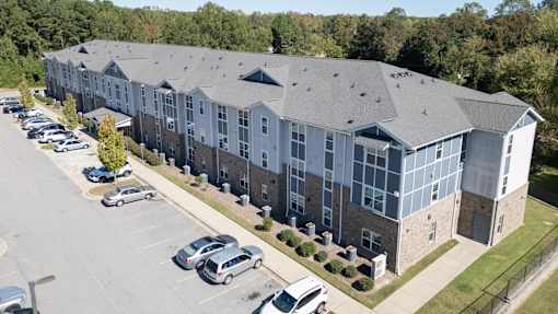 A large building with a parking lot in front.
