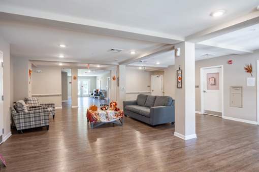 A living room with a couch, chair, and dining table.