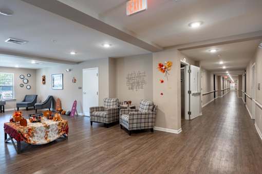 A long hallway with a table and chairs on the left side.