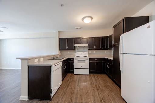 A kitchen with black cabinets and white appliances.
