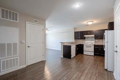 A kitchen with white appliances and black cabinets.