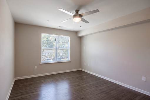 A room with a ceiling fan and a window.