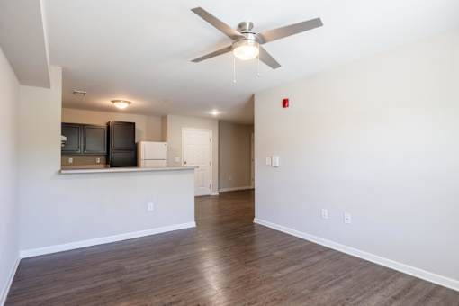 A room with a ceiling fan and wooden flooring.