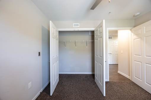 A large, empty room with a carpeted floor and white walls.