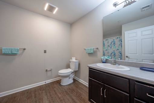 A white toilet sits in a bathroom next to a white sink.